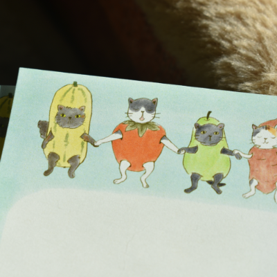 Closeup of stationery featuring cats in veggie costumes